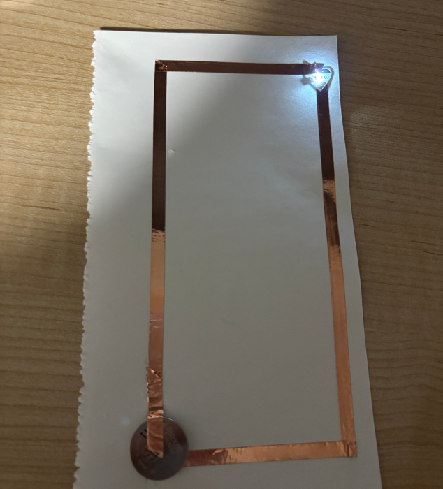 A paper circuit powered on and lit up.