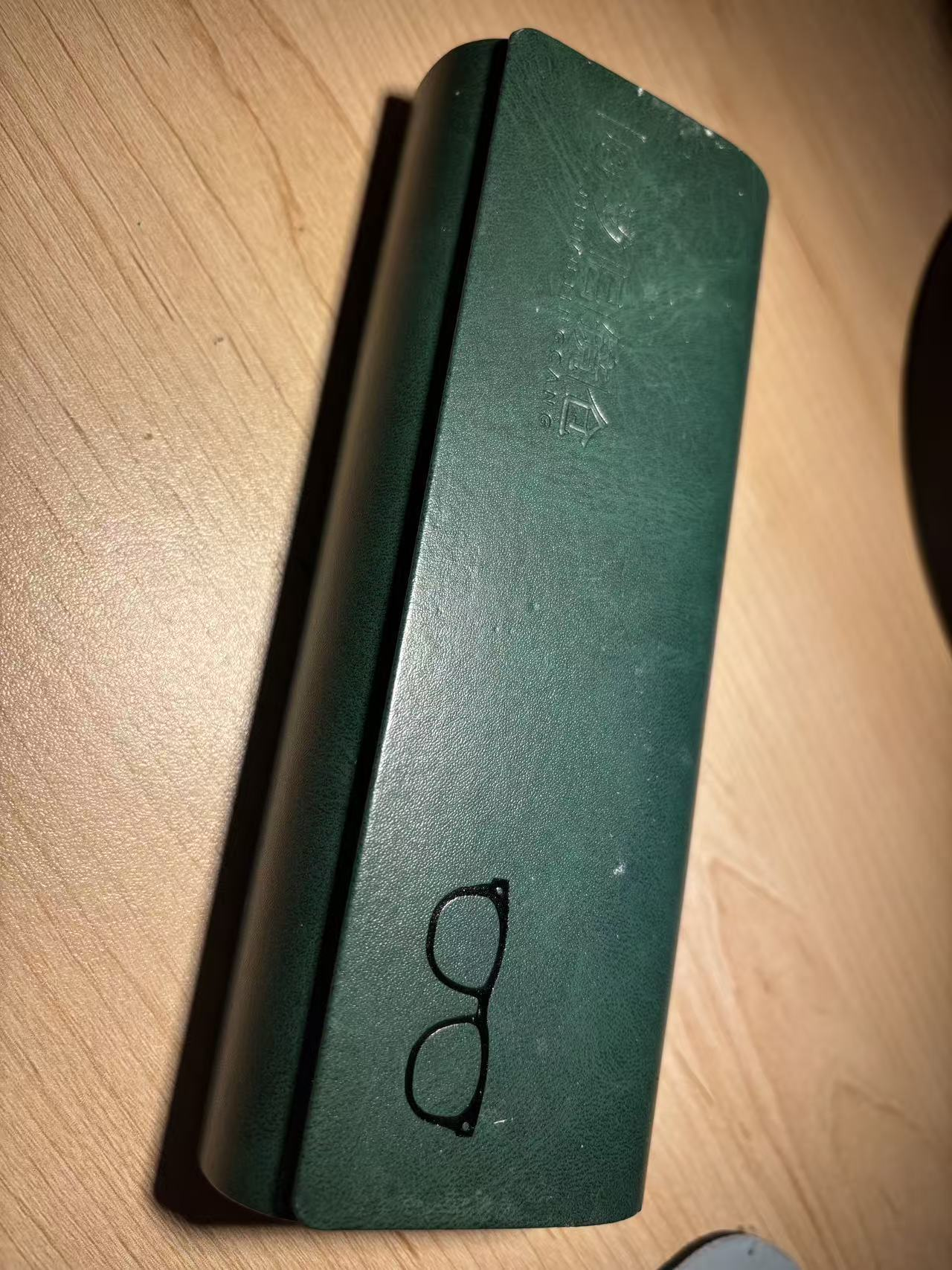 A leather glasses case with an eyewear pattern.