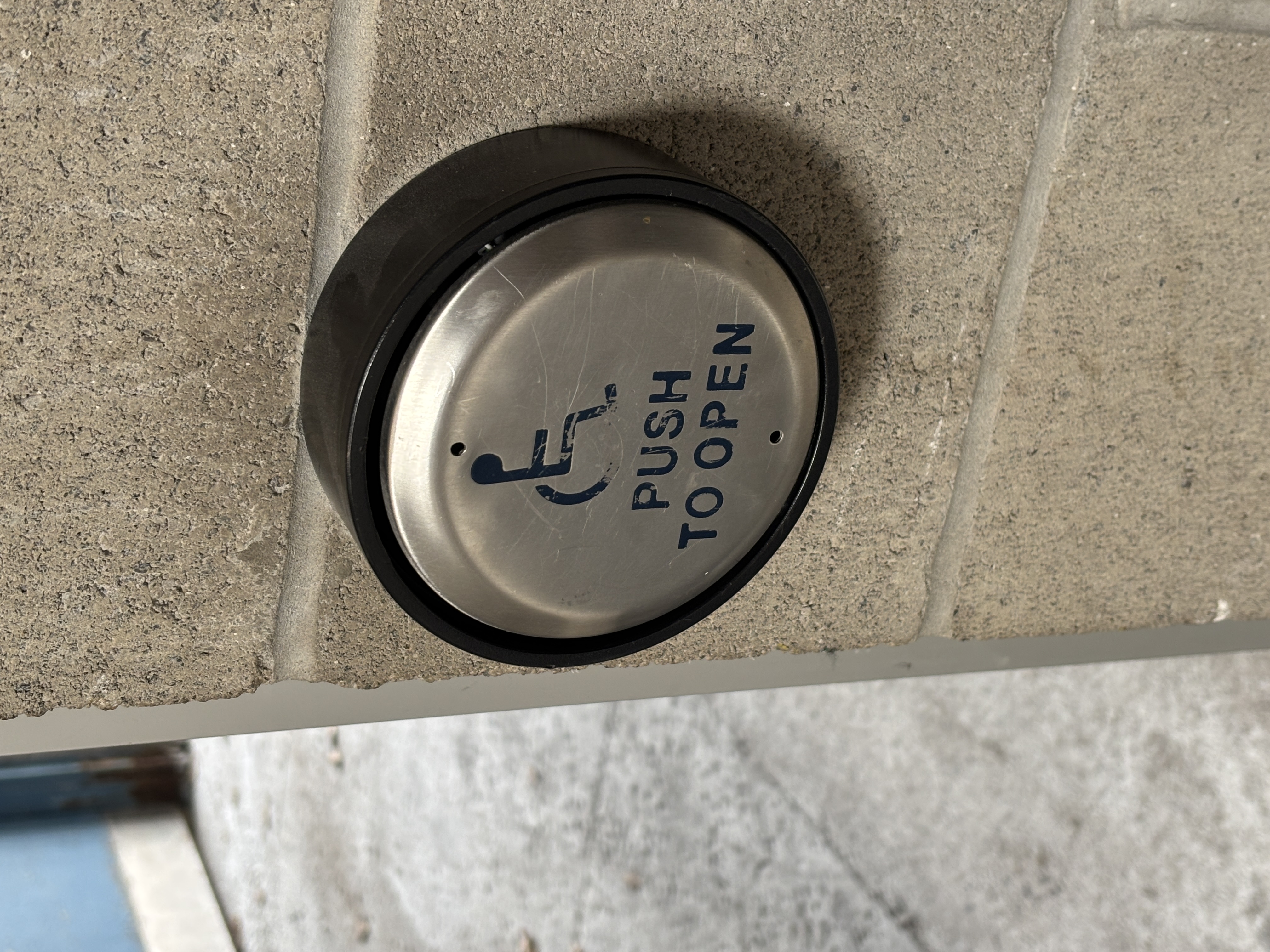 Accessible door button that makes a mechanical trigger sound when pressed.