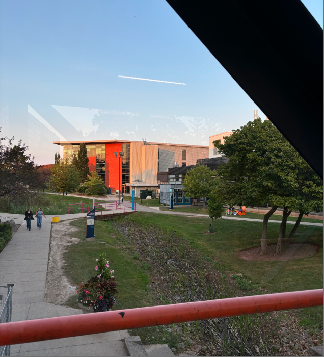 The scene depicted in the photo is the exterior of the SCATE building, photographed from the glass corridor 1 of the Sheridan School B building.